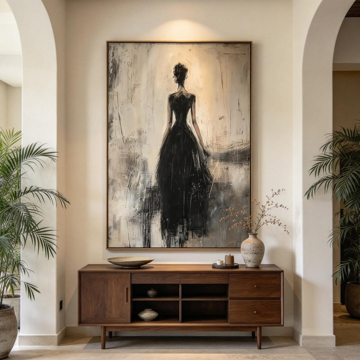 Large neutral silhouette painting above a walnut console in an arched entryway